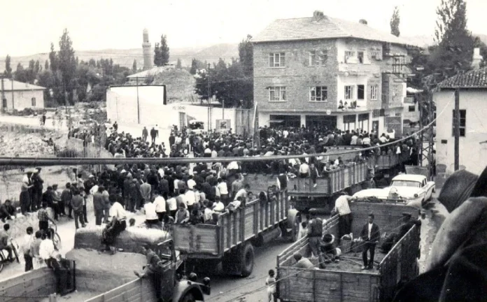 1968 yerel seçimlerinde Aksaray Gündoğdu Caddesi’nde, Aksaray Lisesi önünde çekilen bu fotoğraf; kamyon kasalarında ve yürüyerek ilerleyen kalabalığın coşkusunu yansıtırken, arka plandaki Eğri Minare ile dönemin şehir dokusunu bir arada sunan nostaljik bir tarihi belge niteliği taşıyor.
